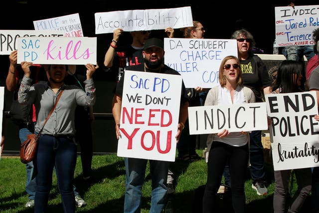 Protesters hold signs during a march downtown after the funeral of Stephon Clark, in Sacramento, California
