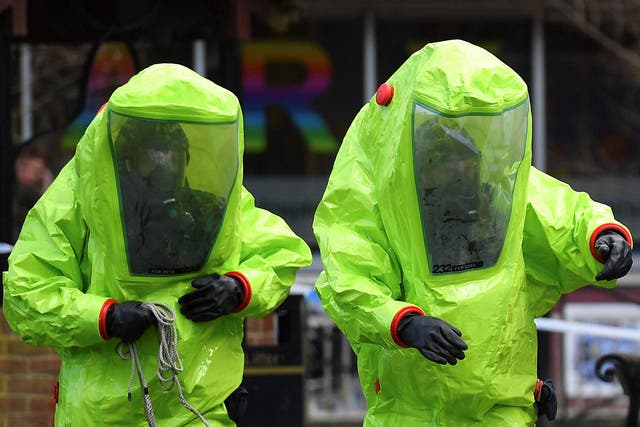 Members of the emergency services in green biohazard suits work near the bench where former Russian spy Sergei Skripal and his daughter Yulia were found in critical condition