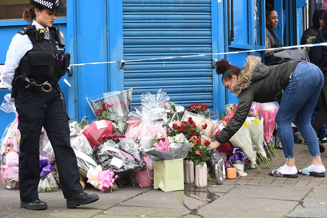 A woman lays flowers on Chalgrove Road