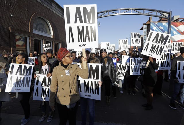 People hold signs resembling the signs carried by striking sanitation workers in 1968 as they join in events commemorating the 50th anniversary of the assassination of the Rev. Martin Luther King Jr