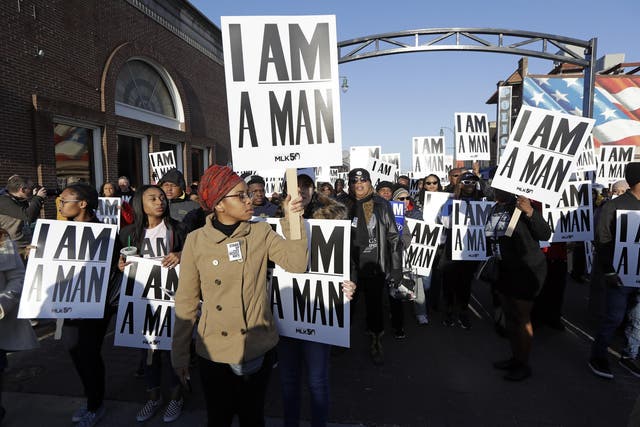 People hold signs resembling the signs carried by striking sanitation workers in 1968 as they join in events commemorating the 50th anniversary of the assassination of the Rev. Martin Luther King Jr