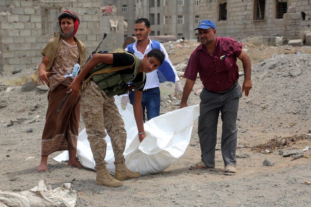 Men carry the body of a victim who was killed in an air strike in the district of Al-Hali in Hodeida province, Yemen, on 2 April 2018