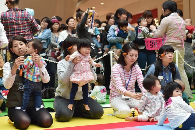 Babies and their mothers take part in a baby crawling competition in Yokohama
