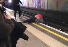 Alarming video shows men fall onto tracks seconds before train