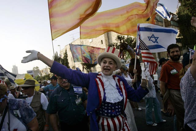 In this file photo a Christian evangelical woman dressed in an 'Uncle Sam' costume waves to onlookers during a parade in celebration of the Jewish holiday of Sukkoth in downtown Jerusalem