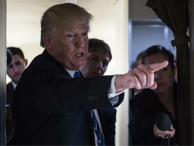 US President Donald Trump gestures as he speaks to reporters on board Airforce One as he travels back to Washington, DC on 5 April 2018