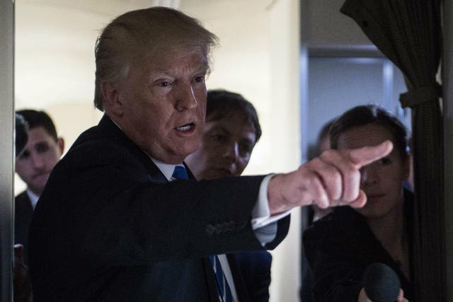 US President Donald Trump gestures as he speaks to reporters on board Airforce One as he travels back to Washington, DC on 5 April 2018