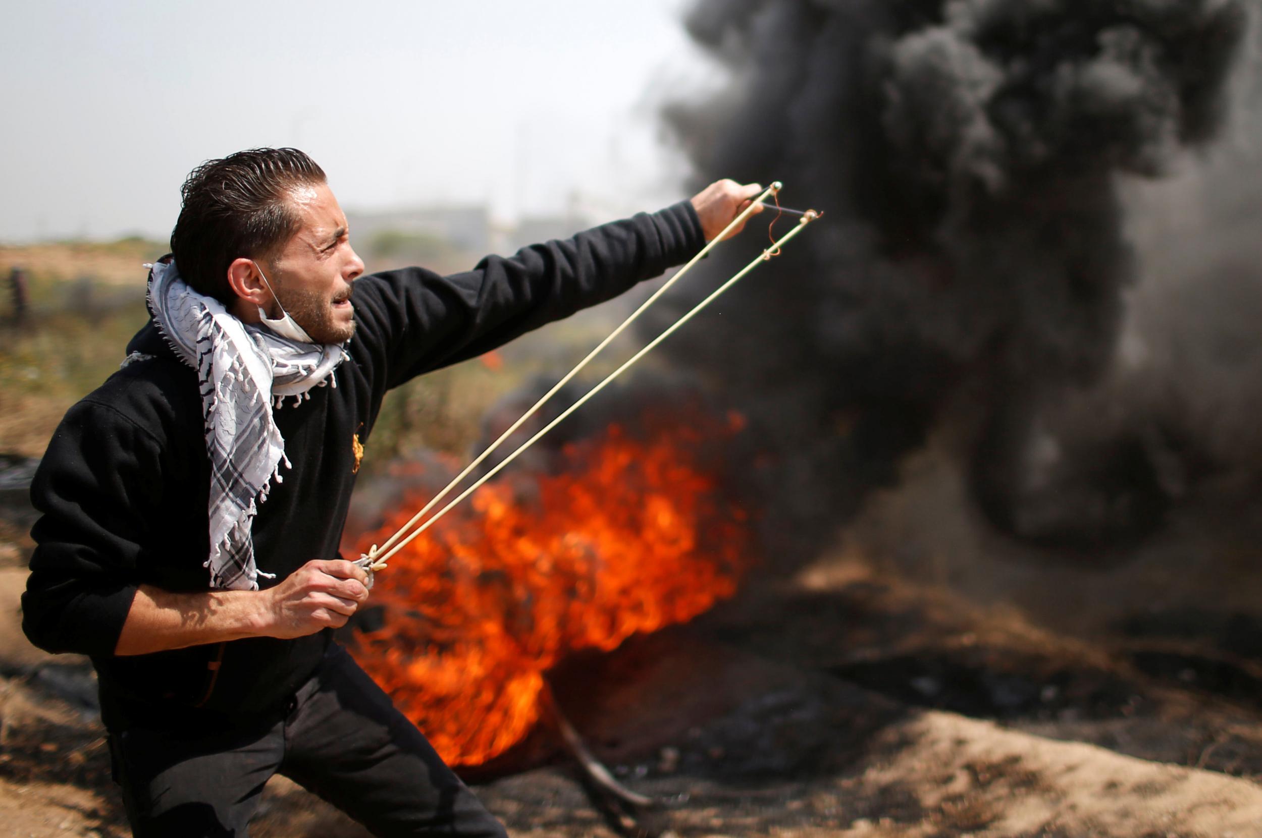 A Palestinian shoots a missile at Israeli troops in the border violence
