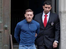 McGregor pictured in handcuffs leaving police station after arrest