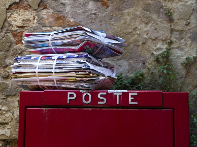 A stack of letters atop a postbox in Italy, where police have arrested a postal worker over 400kg of undelivered mail