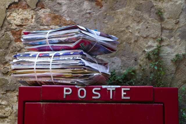 A stack of letters atop a postbox in Italy, where police have arrested a postal worker over 400kg of undelivered mail