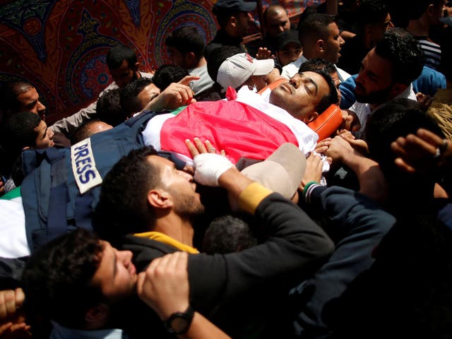 ATTENTION EDITORS - VISUAL COVERAGE OF SCENES OF INJURY OR DEATH Colleagues of Palestinian journalist Yasser Murtaja, 31, who died of his wounds during clashes at the Israel-Gaza border on Friday, carry his body during his funeral in Gaza city April 7, 2018. REUTERS/Suhaib Salem  TEMPLATE OUT