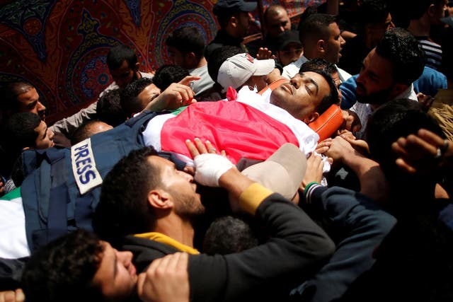 ATTENTION EDITORS - VISUAL COVERAGE OF SCENES OF INJURY OR DEATH Colleagues of Palestinian journalist Yasser Murtaja, 31, who died of his wounds during clashes at the Israel-Gaza border on Friday, carry his body during his funeral in Gaza city April 7, 2018. REUTERS/Suhaib Salem  TEMPLATE OUT