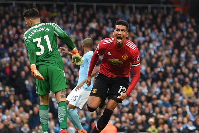 Chris Smalling celebrates after giving Manchester United victory over Manchester City