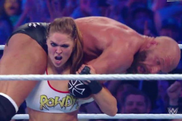 Ronda Rousey lifts Triple H onto her shoulder during her and Kurt Angle's victory at WrestleMania