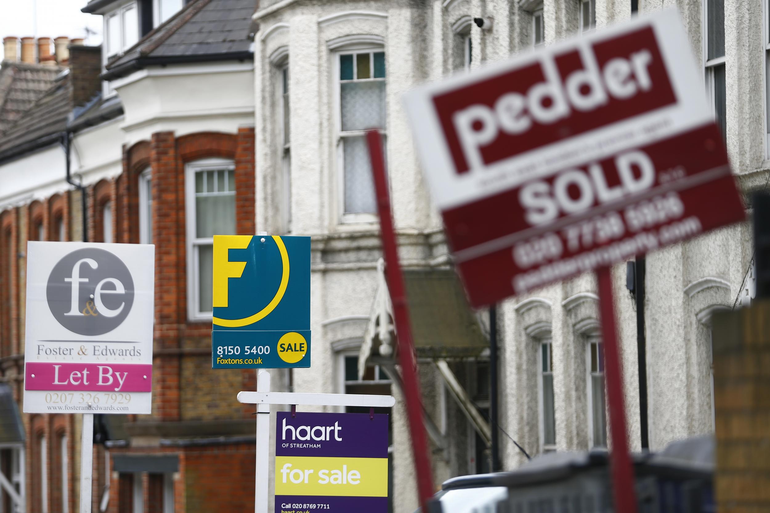For sale signs on a busy looking street, but the UK housing market is stuck in the mud