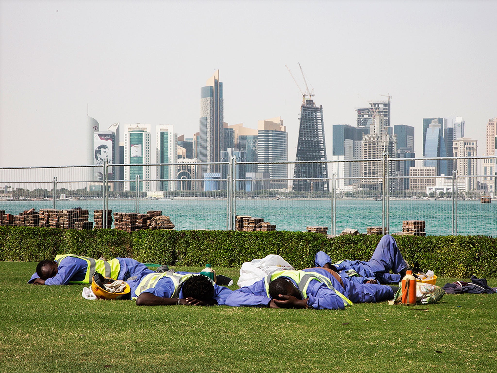 Workers sleep in the sun as construction continues in Doha