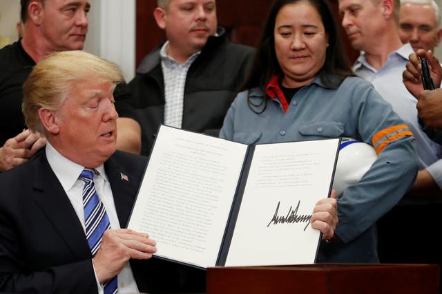 Trump signs a presidential proclamation placing tariffs on steel and aluminum imports