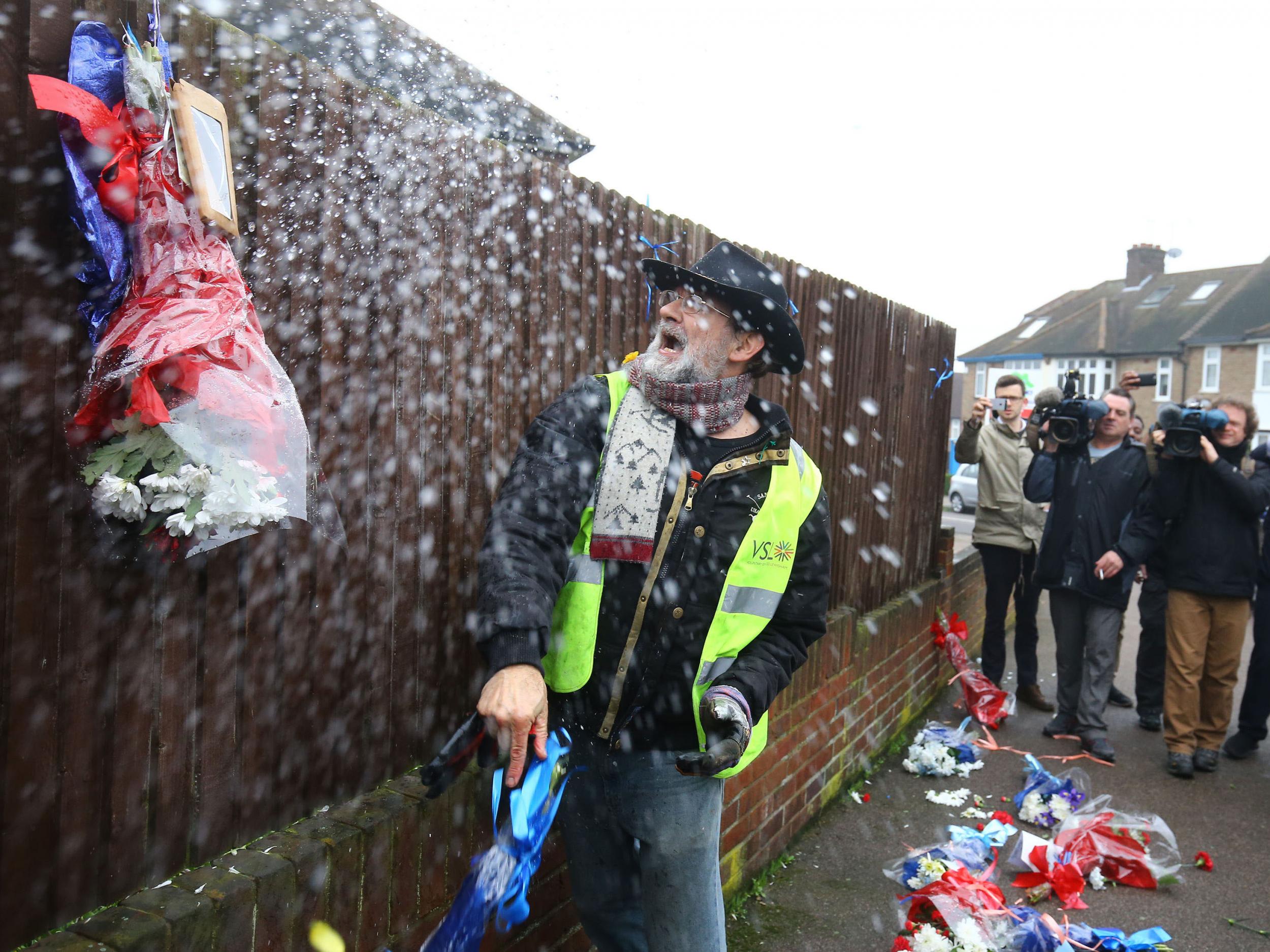 Iain Gordon pulls down flowers left for Henry Vincent in Hither Green, south-east London