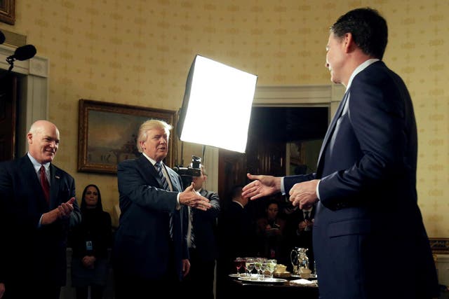 U.S. President Donald Trump greets Director of the FBI James Comey as Director of the Secret Service Joseph Clancy (L), watches during the Inaugural Law Enforcement Officers and First Responders Reception in the Blue Room of the White House