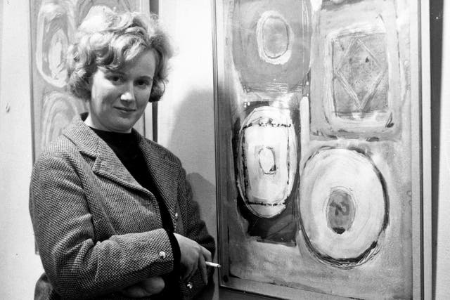 Ayres smokes a trademark Player’s Navy Cut cigarette as she poses with one of her paintings at a 1962 exhibition of her work in London