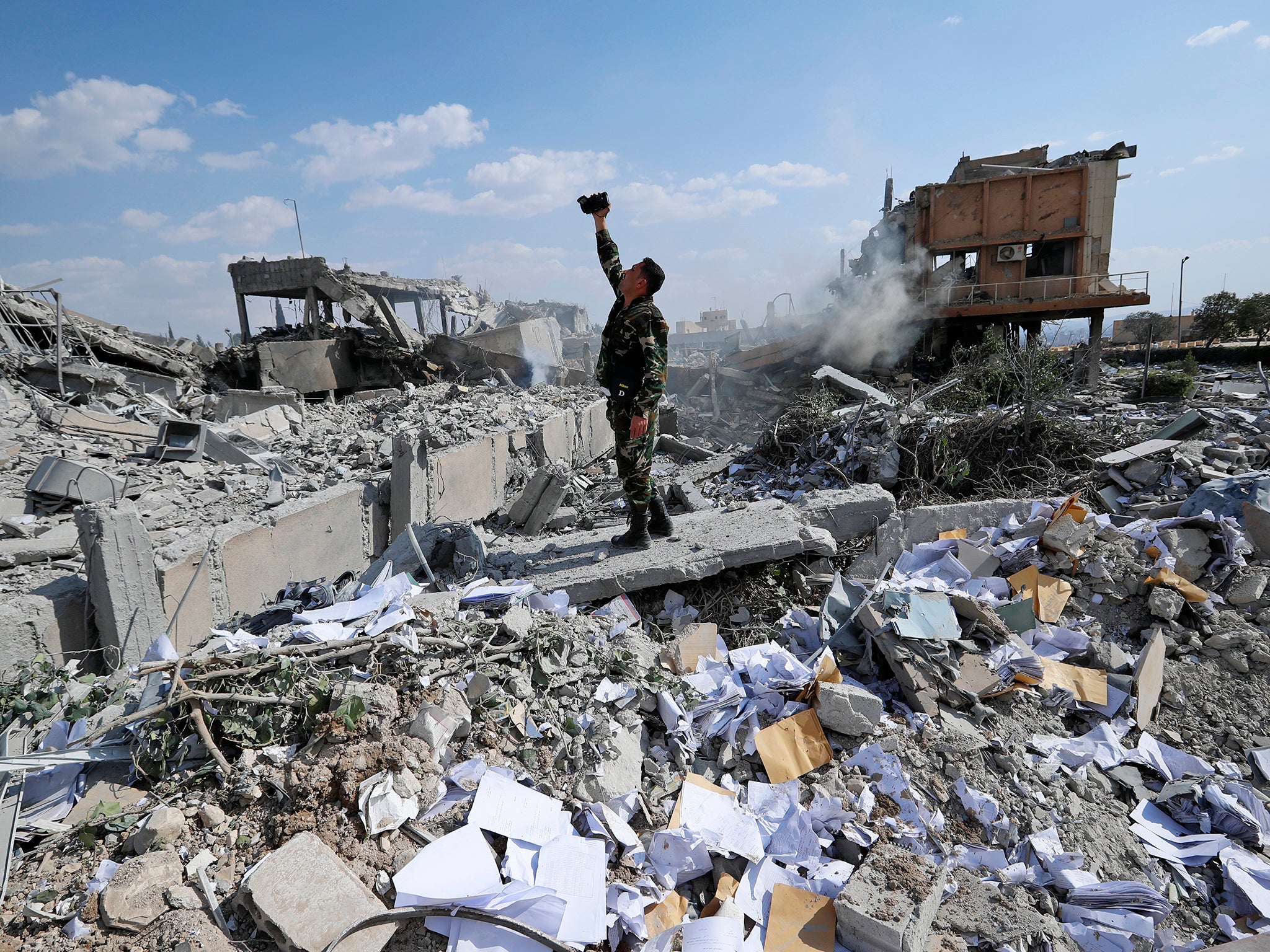 A Syrian soldier films the damage of the Syrian Scientific Research Center