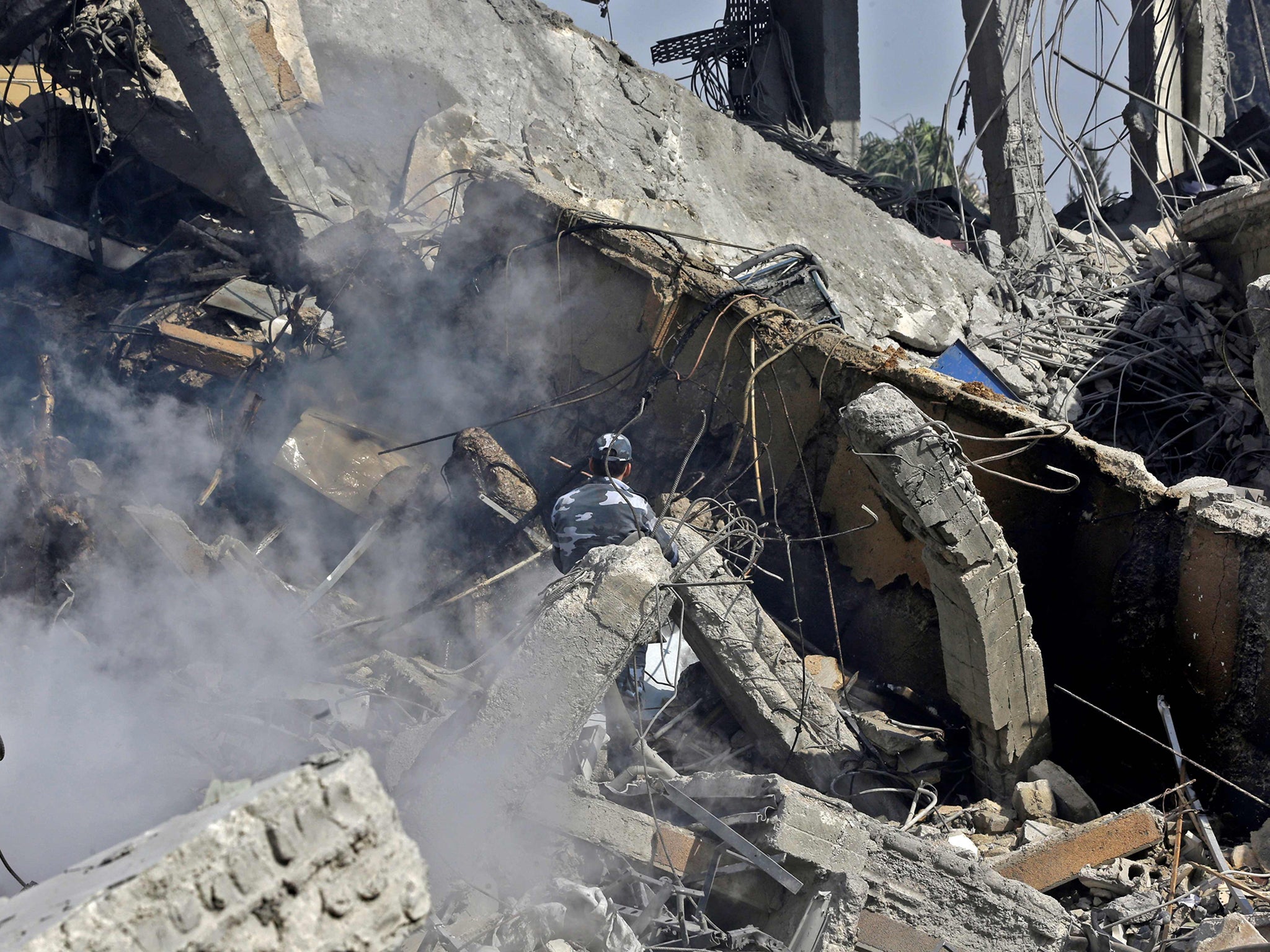 A Syrian soldier sprays water on the wreckage