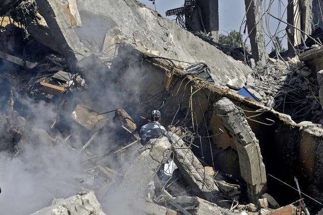 A Syrian soldier sprays water on the wreckage