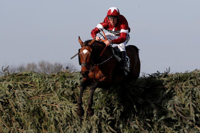 Tiger Roll and Davy Russell leap over a fence on their way to glory in the Grand National