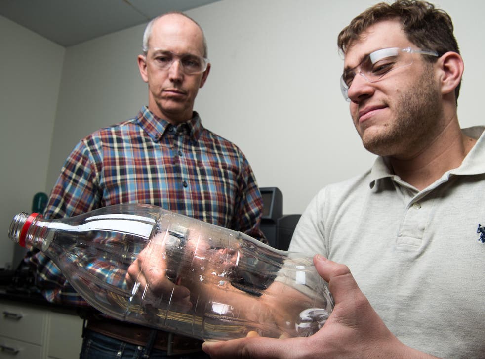 Scientists Bryon Donohoe and Nic Rorrer taking samples from a PET bottle as part of their investigation into plastic-eating enzymes