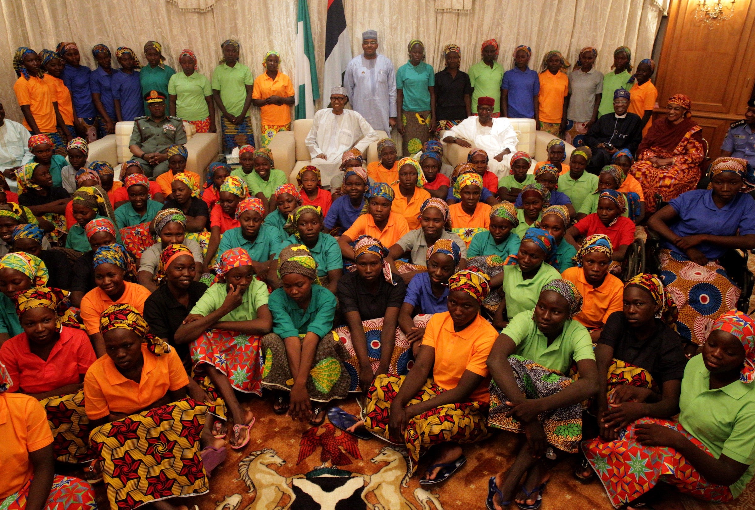 President of Nigeria, Muhammadu Buhari, (rear centre) with relatives of Boko Haram captives after the release of 82 Chibok girls last year