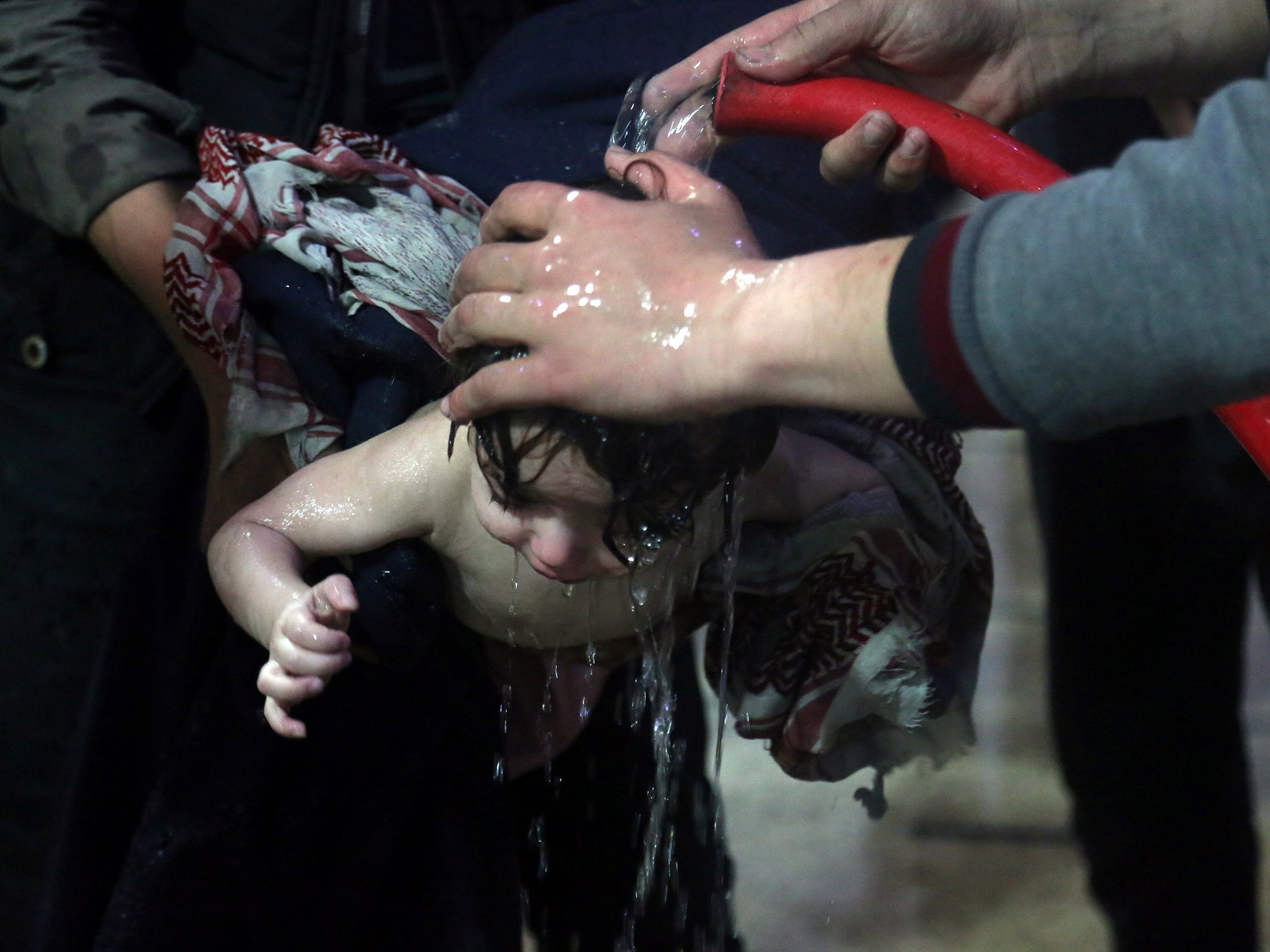 A child is treated in a hospital in Douma (White Helmets/Handout via Reuters)