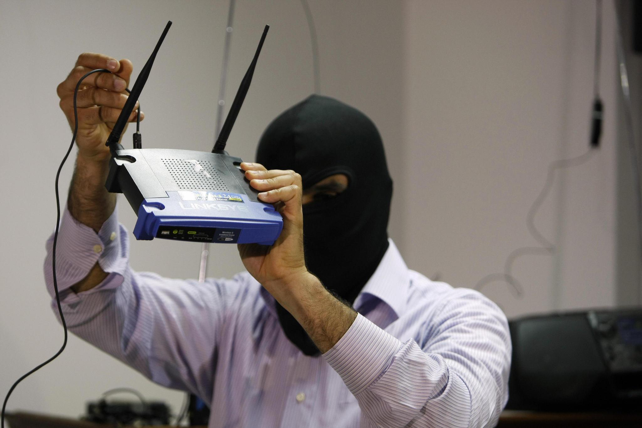 A masked Lebanese secret service officer shows to the media at the Lebanese security services headquarters in Beirut on May 11, 2009 a wireless internet router found with arrested Lebanese nationals