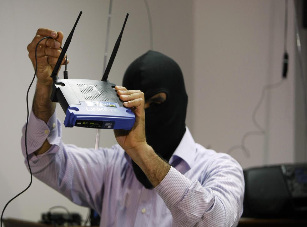 A masked Lebanese secret service officer shows to the media at the Lebanese security services headquarters in Beirut on May 11, 2009 a wireless internet router found with arrested Lebanese nationals