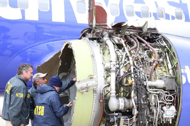 NTSB investigators examine damage to the engine of the Southwest Airlines plane