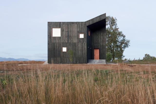 The home takes inspiration from local volcanic sand for the charcoal colour of the external timber panels