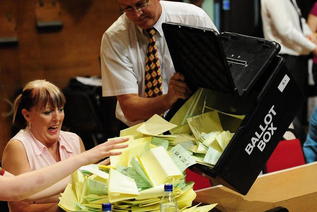 Local election ballot papers are emptied from a ballot box before being sorted and counted in Preston