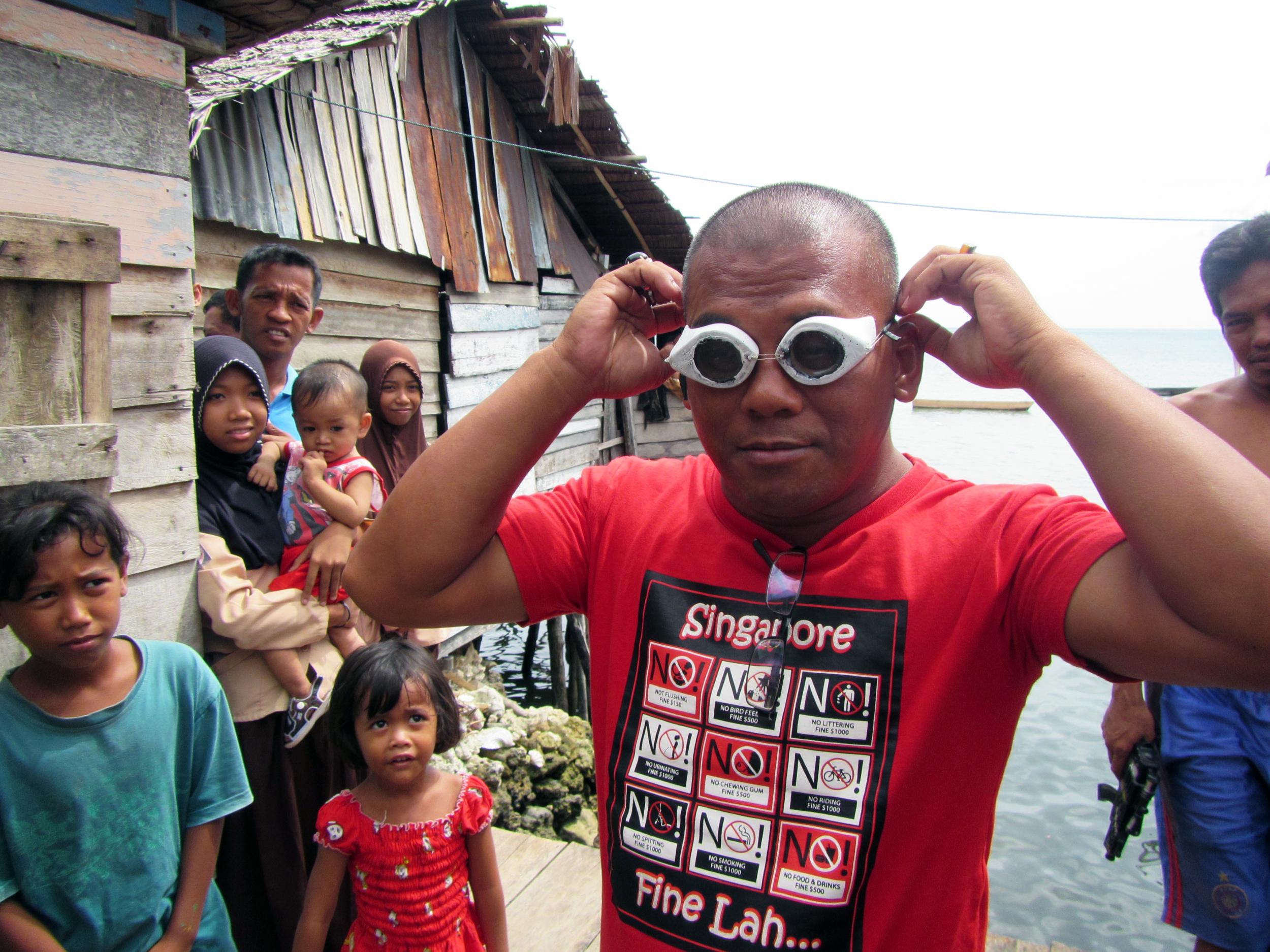 A Bajau villager demonstrates the use of traditional wooden goggles