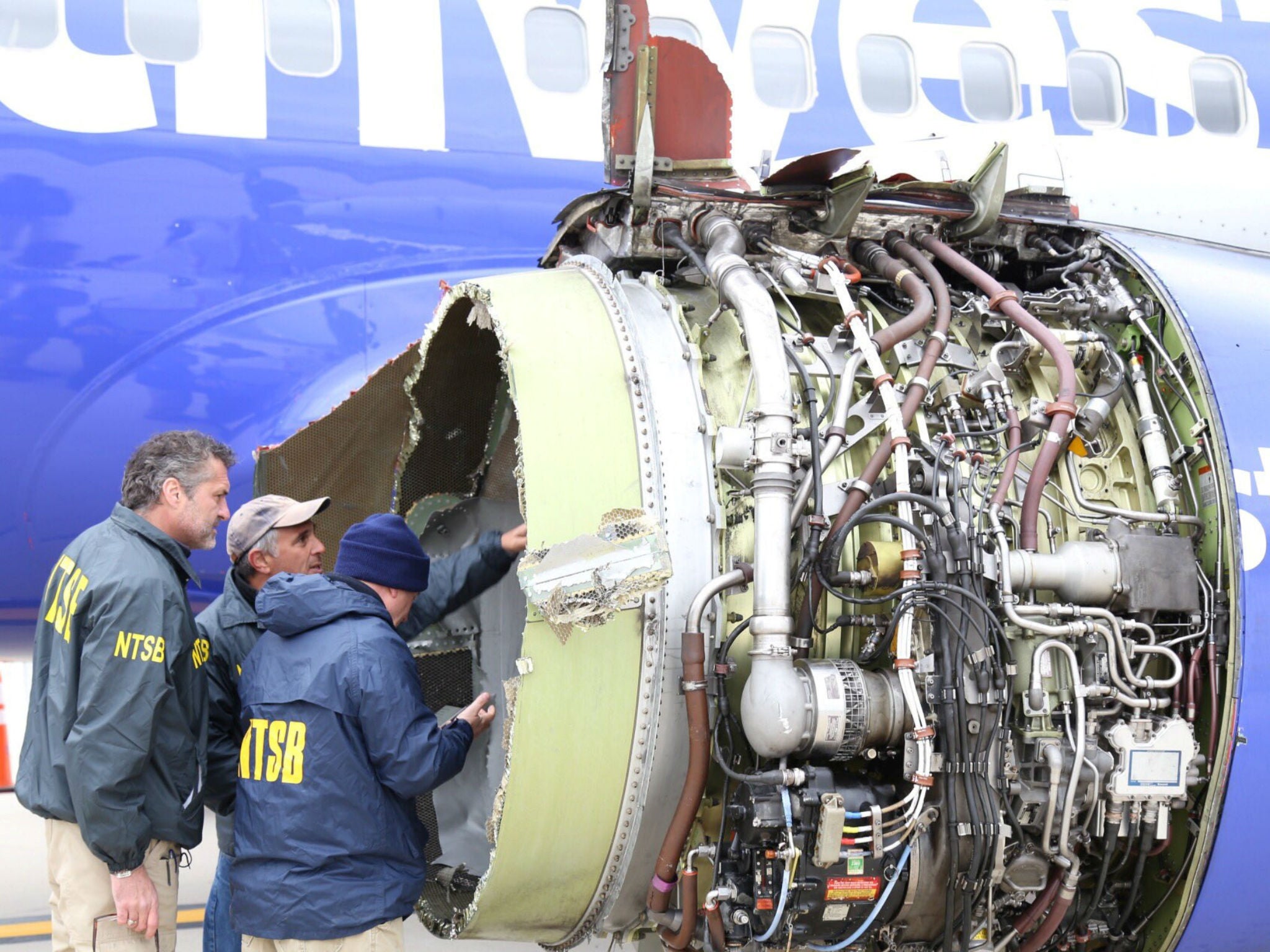 Investigators examine damage to the engine of the Southwest Airlines plane