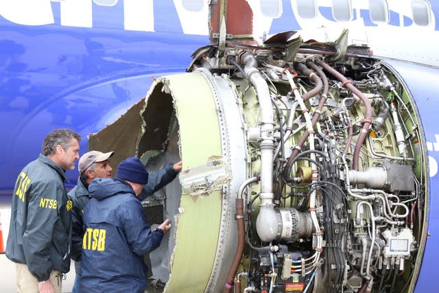 Investigators examine damage to the engine of the Southwest Airlines plane