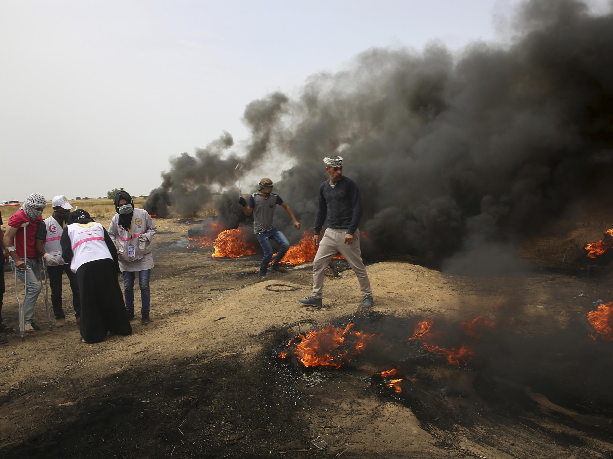 Palestinian protesters hurl stones at Israeli troops during clashes with Israeli troops along Gaza's border with Israel on Friday