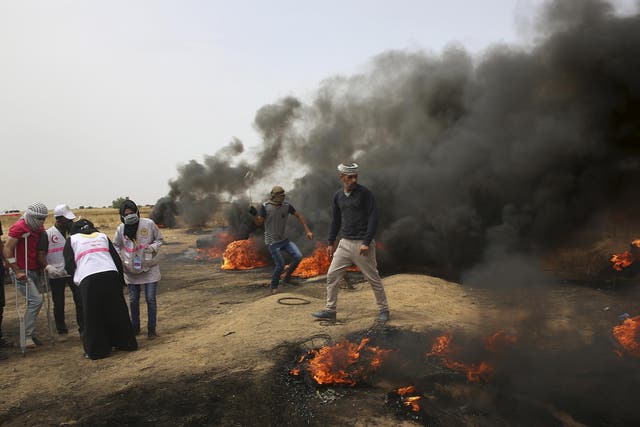 Palestinian protesters hurl stones at Israeli troops during clashes with Israeli troops along Gaza's border with Israel