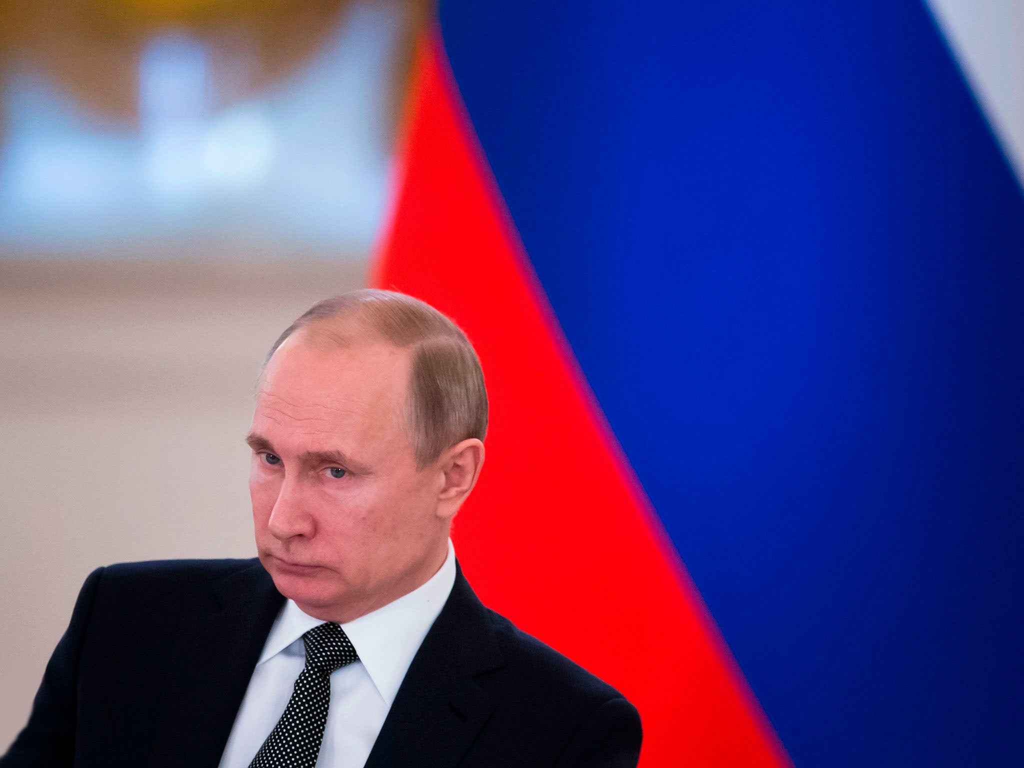 Russian President Vladimir Putin looks on