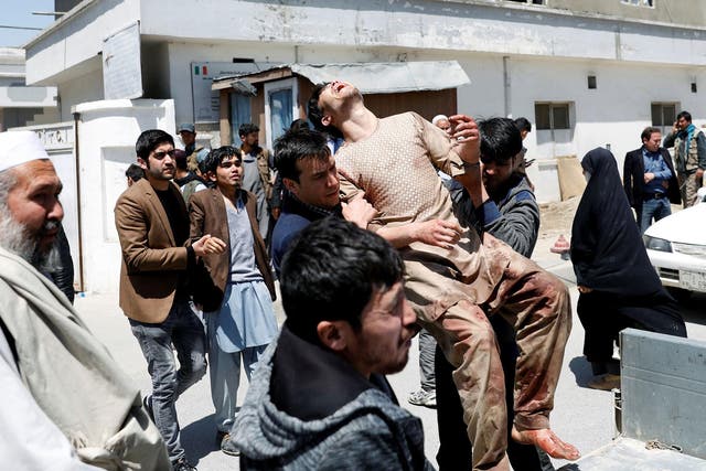Relatives of the victims carry an injured man outside a hospital after a suicide attack in Kabul