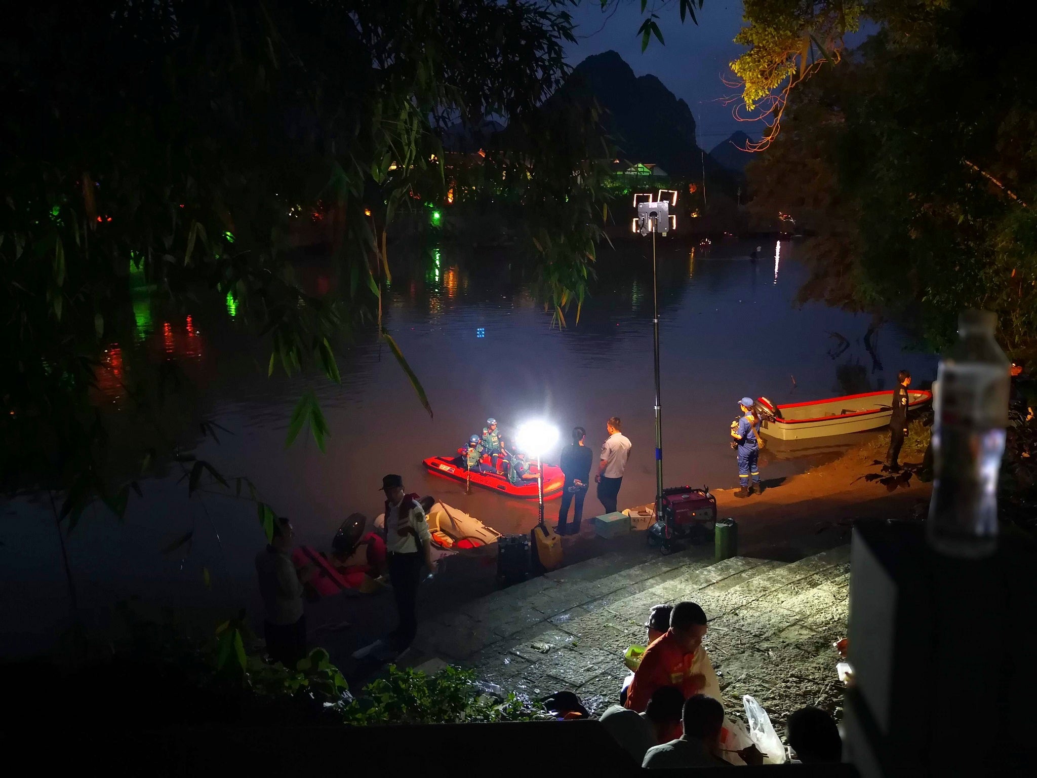 Rescuers search for missing boaters into the night after two dragon boats capsized in southern China, killing seventeen people