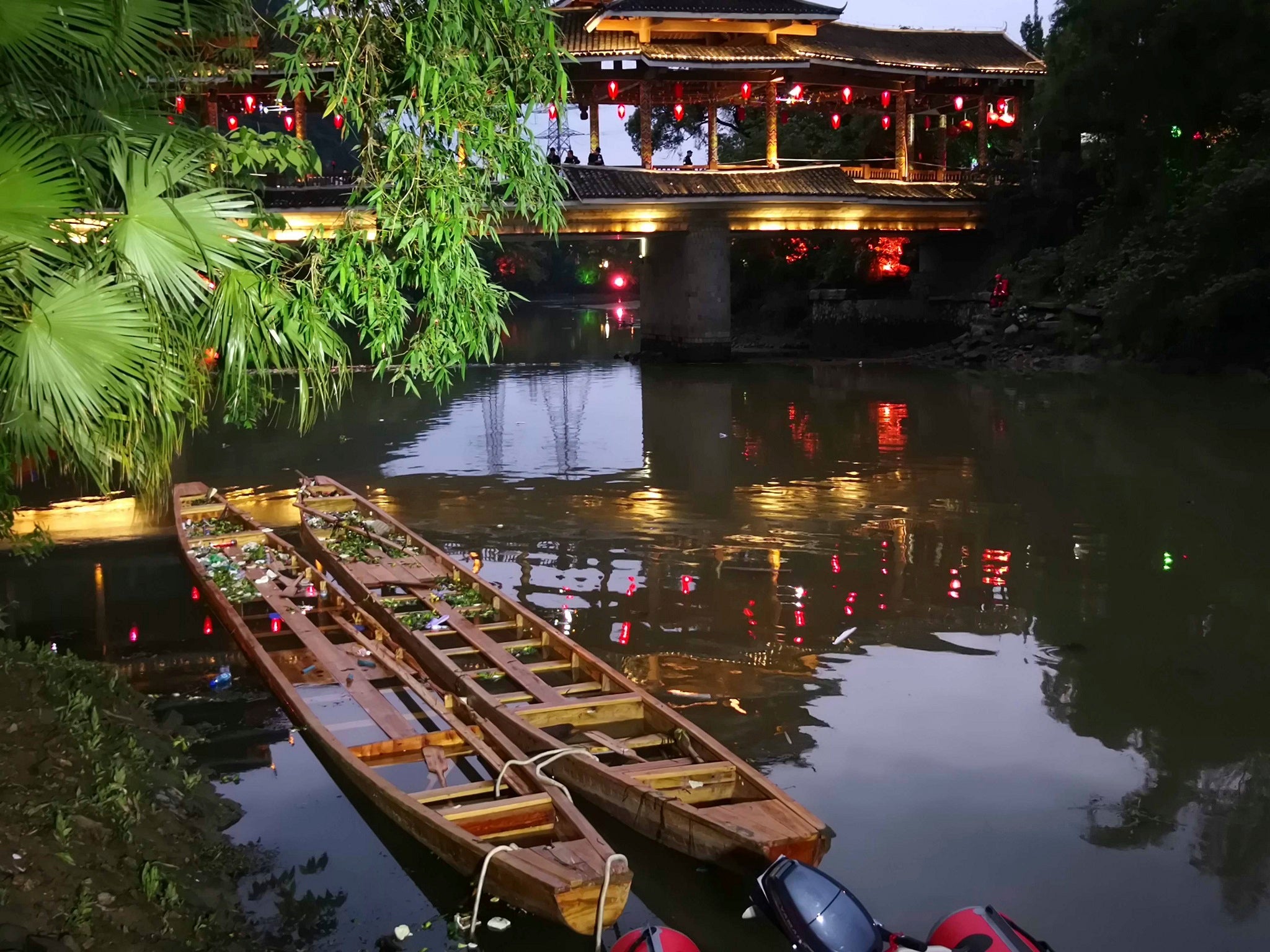 Two dragon boats that capsized, killing seventeen people, sit in the water on the Taohua River in Guilin in southern China