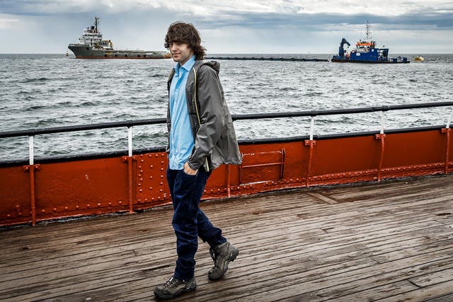 Boyan Slat, who started devising the giant system when he was a student, and in the background, a prototype of the system