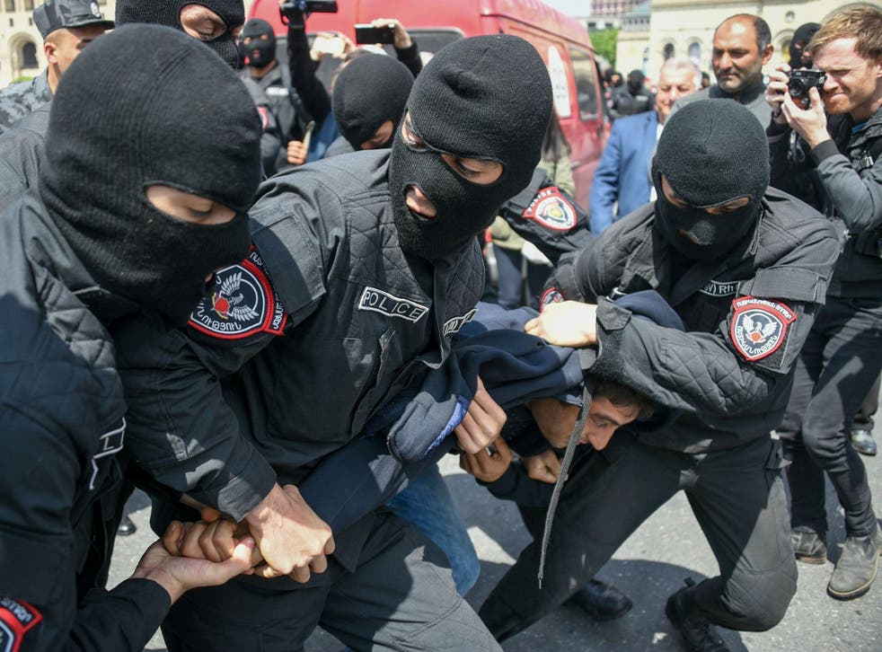 Armenian policemen detain an opposition supporter during a rally in central Yerevan held to protest the former president's election as prime minister