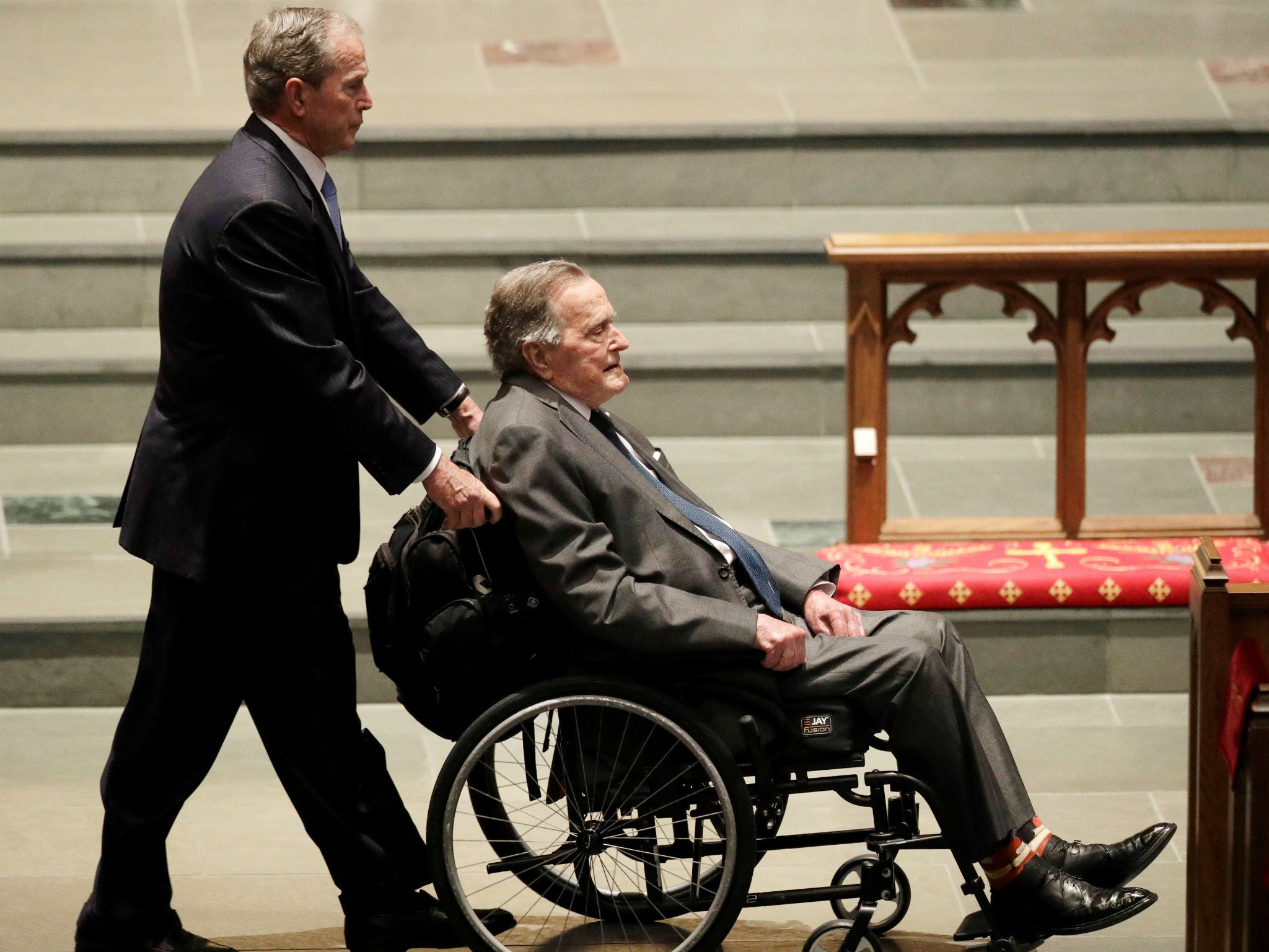 Former president George HW Bush is pushed by his son, former president George W Bush, during funeral services for former first lady Barbara Bush in Houston, Texas