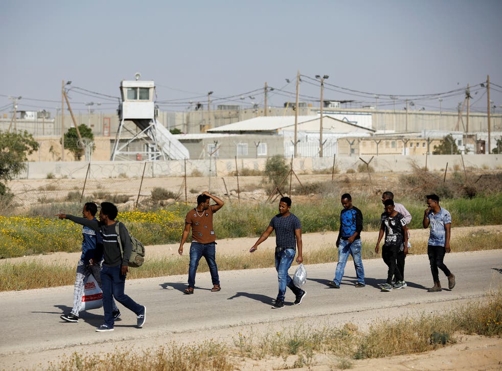 African migrants walk on a road after being released from Saharonim Prison in the Negev desert, Israel